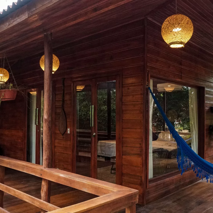 Veranda mit Hängematte in der Manati Lodge im Amazonas, Brasilien, umgeben von üppiger Vegetation.