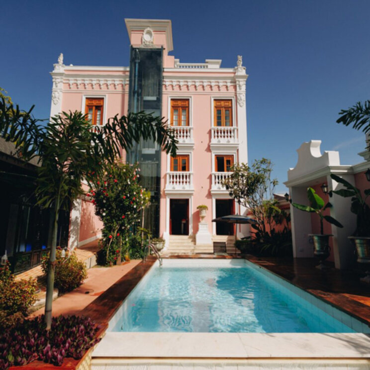 Außenpool vor der rosa Kolonialfassade des Hotels Quinta das Videiras in Florianopolis, Brasilien.