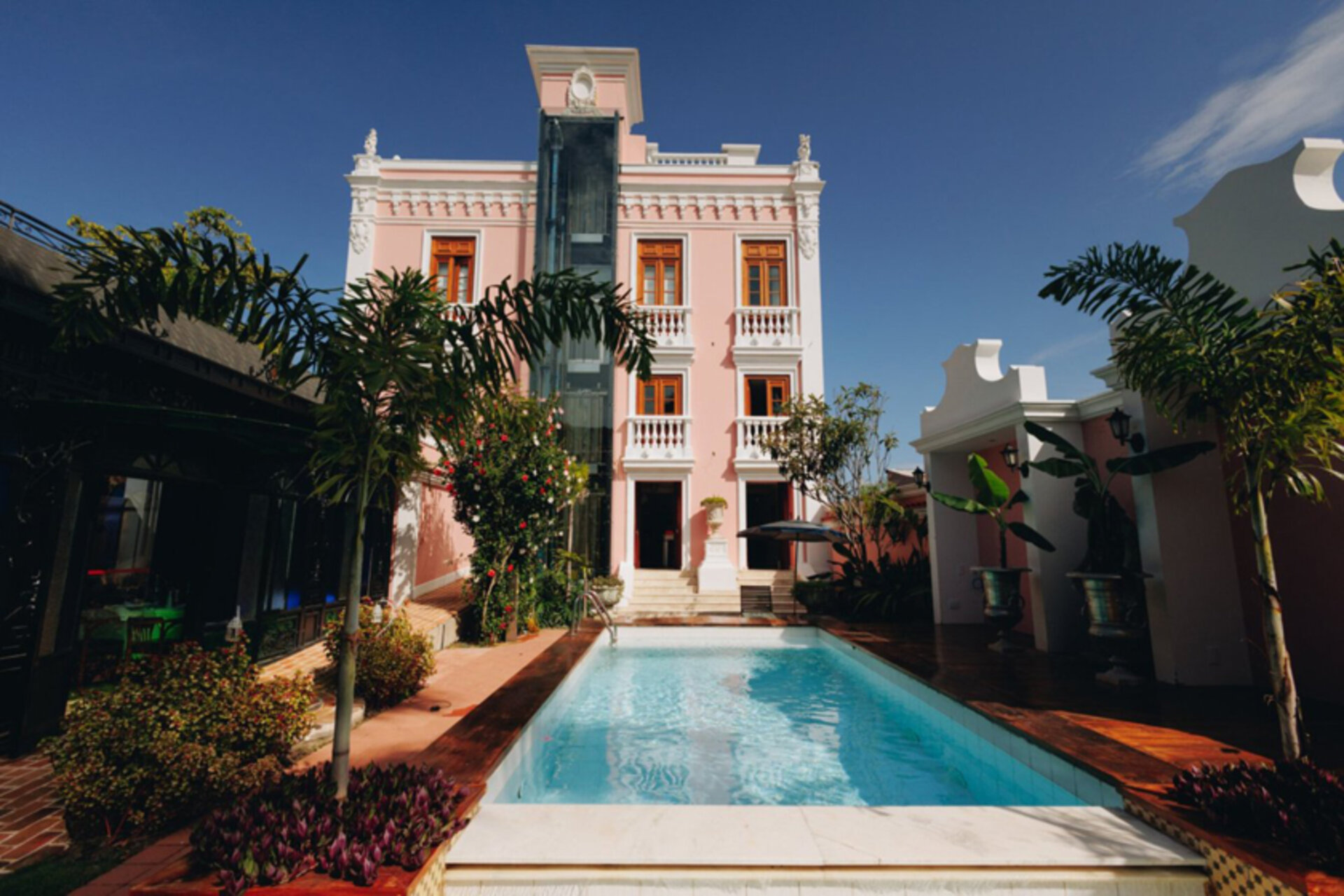 Außenpool vor der rosa Kolonialfassade des Hotels Quinta das Videiras in Florianopolis, Brasilien.