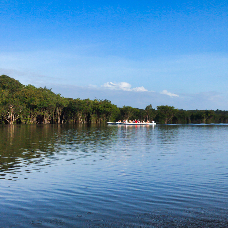 Touristen in einem schmalen Boot auf einem Flussarm des Amazonas bei der Amazon Village Lodge.