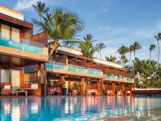 Außenansicht des Essenza Hotels in Jericoacoara, Brasilien, mit seiner modernen Architektur, den privaten Pools und einer idyllischen Lage und großem Pool, umgeben von Palmen.
