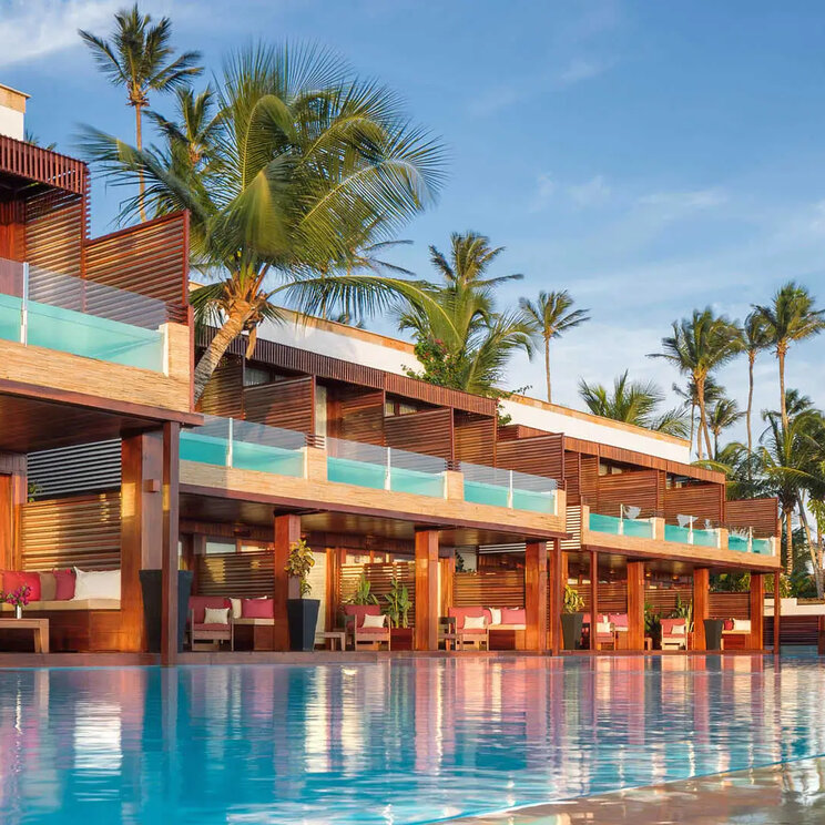 Außenansicht des Essenza Hotels in Jericoacoara, Brasilien, mit seiner modernen Architektur, den privaten Pools und einer idyllischen Lage und großem Pool, umgeben von Palmen.