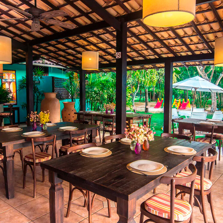 Offener Restaurantbereich des Hotel Porto Zarpa mit Blick in den tropischen Garten nahe dem Strand von Praia do Forte in Bahia, Brasilien.