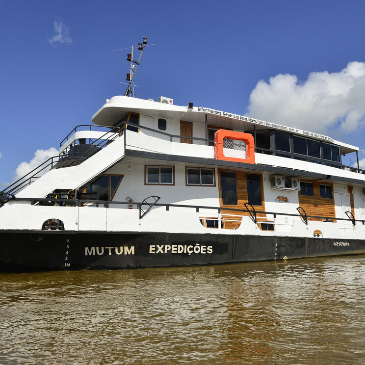 Mutum-Expeditionsboot auf dem Fluss im Pantanal, Brasilien, bei strahlend blauem Himmel.