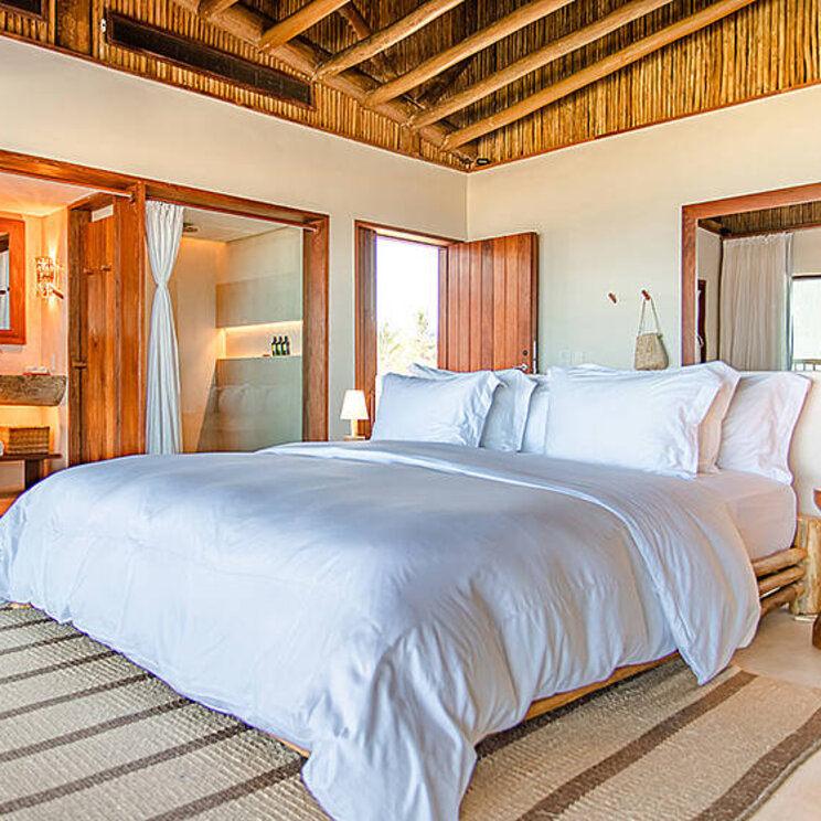 Master Suite im Hotel Villa Mandi in Jericoacoara, Brasilien, mit modernem Design und Zugang zum Badezimmer.