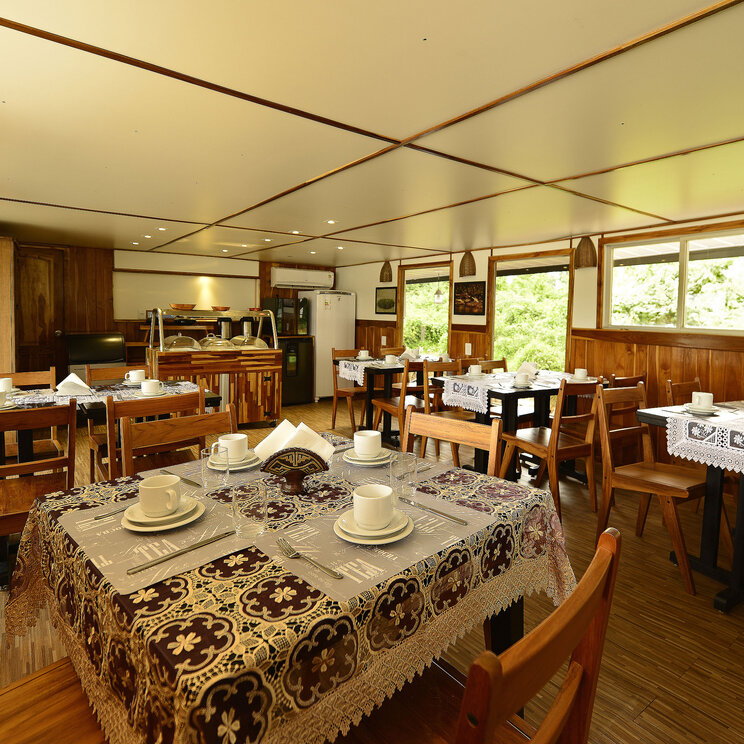 Speiseraum auf dem Mutum-Expeditionsboot im Pantanal, Brasilien, mit gemütlicher Holzausstattung und gedeckten Tischen.